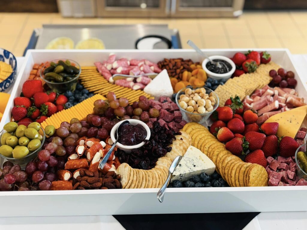 A vibrant spread of fruits, cheeses, and meats invites warmth and connection, perfect for community gatherings.