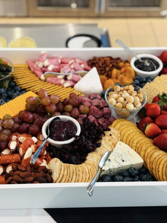A vibrant spread of fruits, cheeses, and meats invites warmth and connection, perfect for community gatherings.