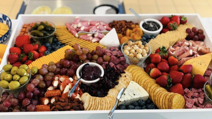 A vibrant spread of fruits, cheeses, and meats invites warmth and connection, perfect for community gatherings.