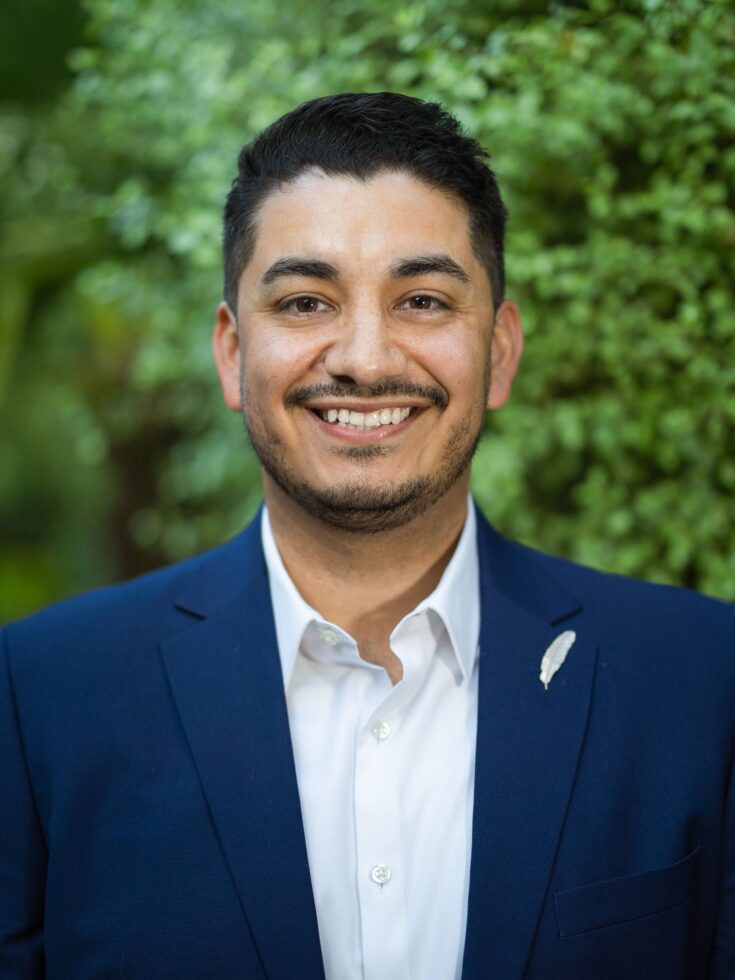 A welcoming smile shines against a lush, green backdrop, radiating warmth and community spirit.