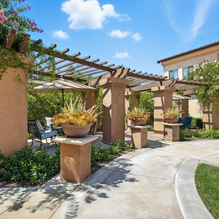 A serene outdoor space featuring lush greenery, inviting seating, and beautiful planters, perfect for relaxation.