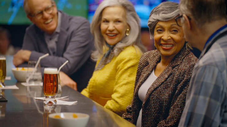 Lively conversation and laughter fill the bar, showcasing a vibrant community enjoying each other's company.