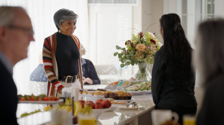 A vibrant gathering with smiling residents enjoying refreshments and warm conversations in a welcoming space.