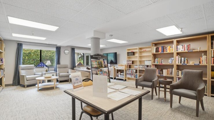A welcoming lounge filled with natural light, inviting seating, and shelves of books for community engagement.