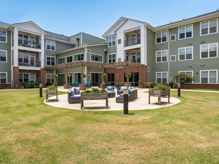 A welcoming outdoor space featuring comfortable seating and lush greenery, perfect for community gatherings.