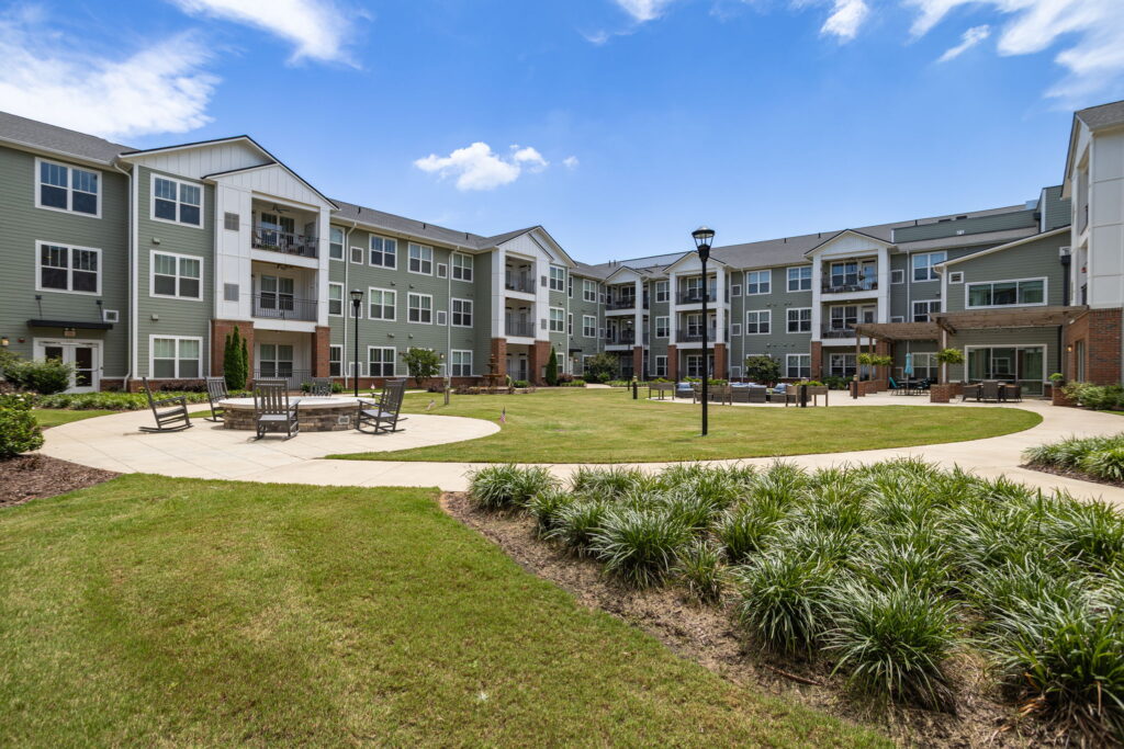 Spacious, well-maintained courtyard with seating areas, greenery, and a welcoming atmosphere.