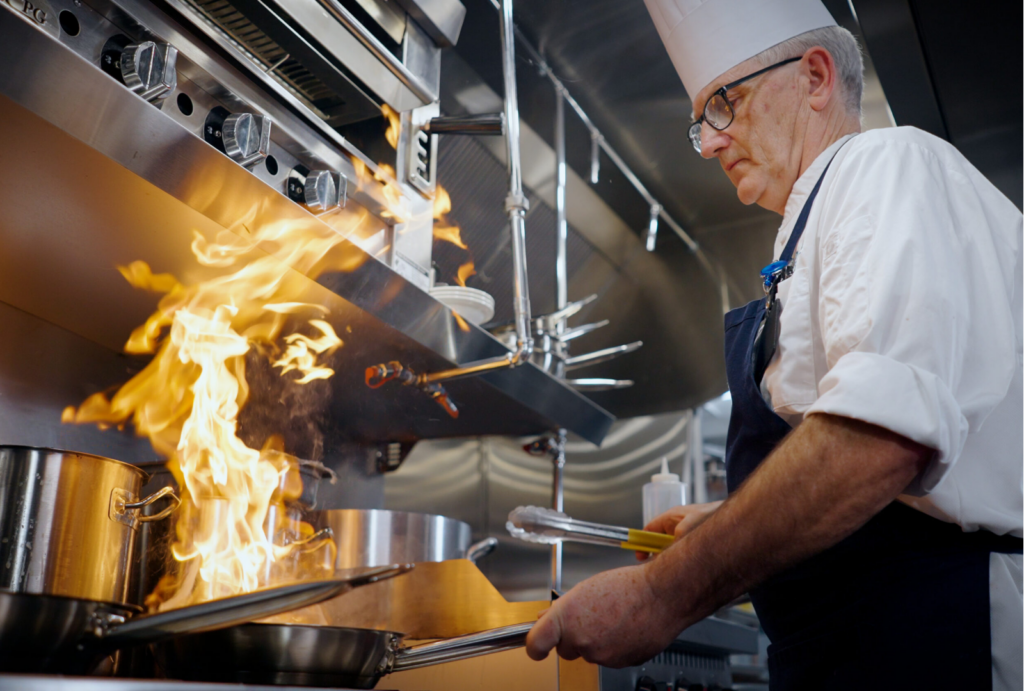 A skilled chef passionately prepares meals in a vibrant kitchen, embodying warmth and community spirit.