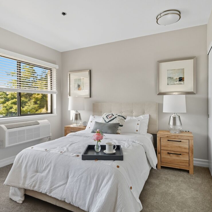 A bright, inviting bedroom with soft decor, showcasing comfort and a welcoming atmosphere.