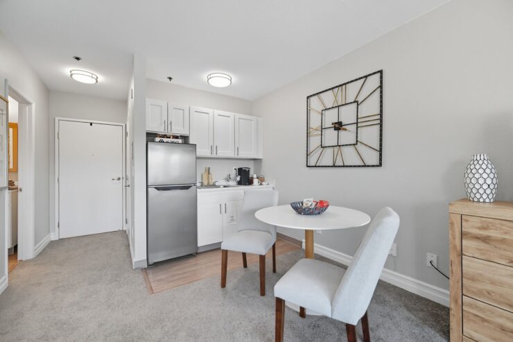 A bright, inviting space featuring a dining area, modern kitchen, and cozy decor, perfect for community living.
