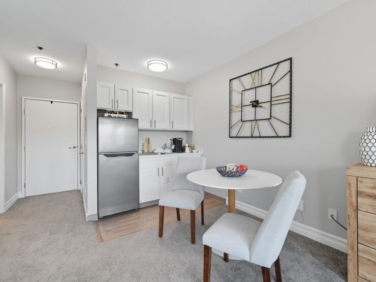 A bright, inviting space featuring a dining area, modern kitchen, and cozy decor, perfect for community living.