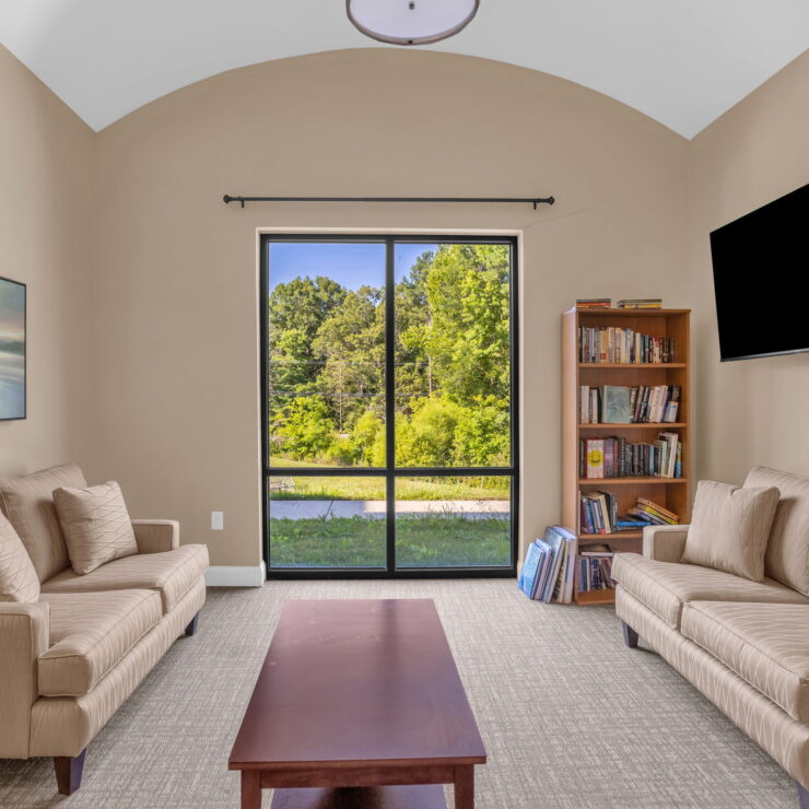 Bright and inviting space featuring comfortable seating, a view of nature, and a welcoming atmosphere.