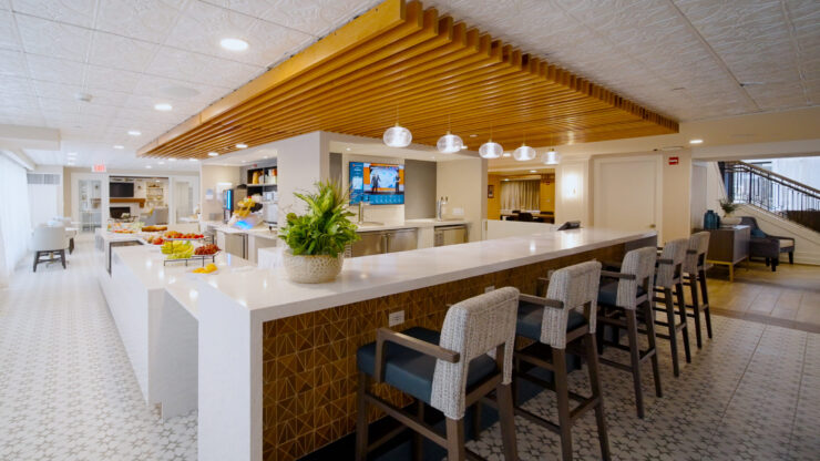 A welcoming communal space featuring a stylish bar, fresh fruit, and cozy seating, perfect for gatherings.