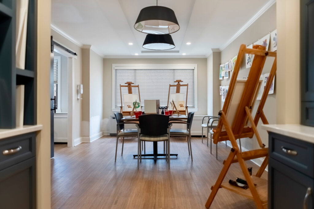 Bright and inviting space for creativity, featuring easels and a communal table, fostering connection.