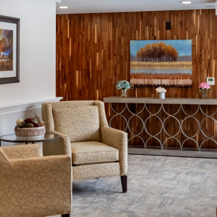 A welcoming lounge features elegant seating and warm wood accents, fostering a sense of community and comfort.