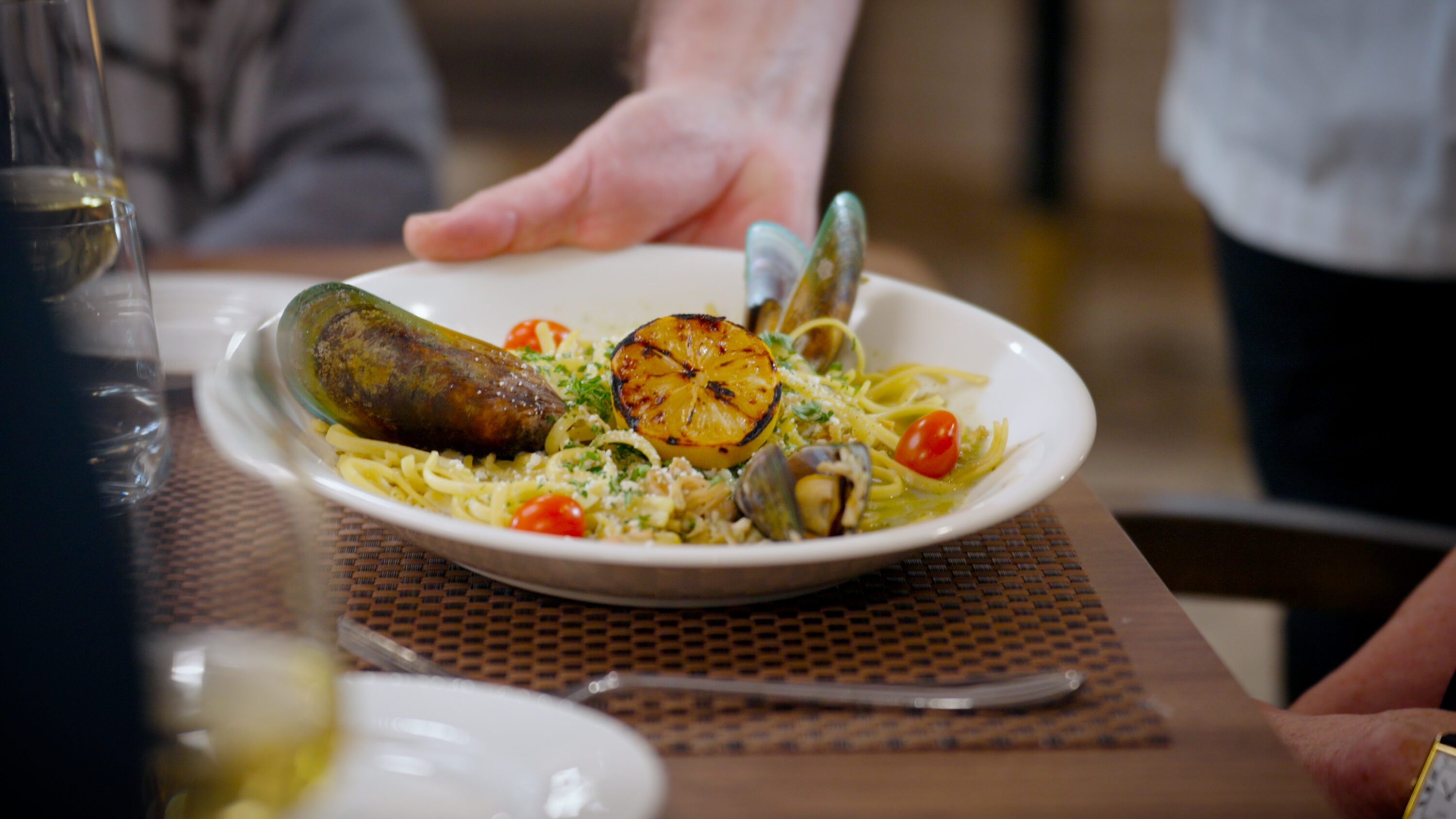 A beautifully plated seafood pasta dish, showcasing vibrant colors and inviting presentation, highlights community dining at its best.