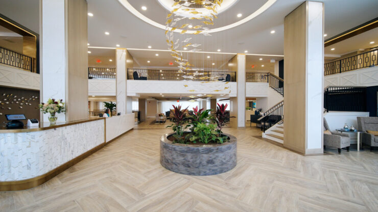 Bright and inviting, the lobby features elegant decor and lush plants, fostering a warm community atmosphere.