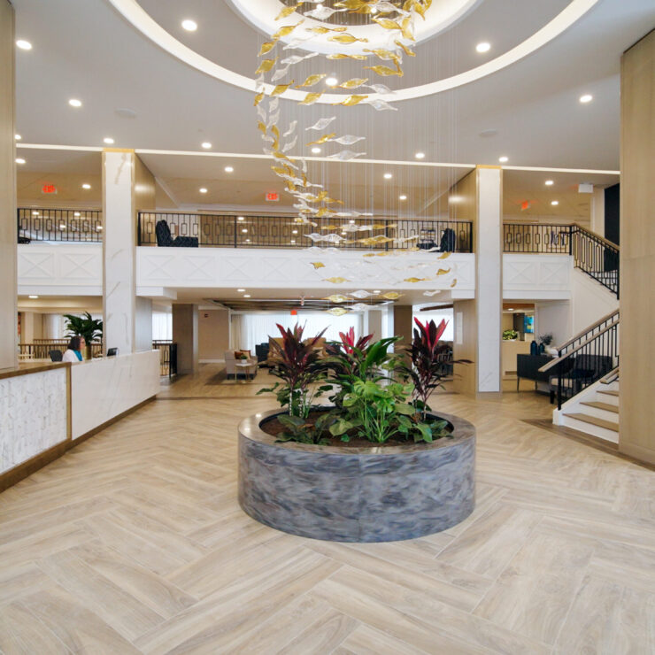 Bright and inviting, the lobby features elegant decor and lush plants, fostering a warm community atmosphere.