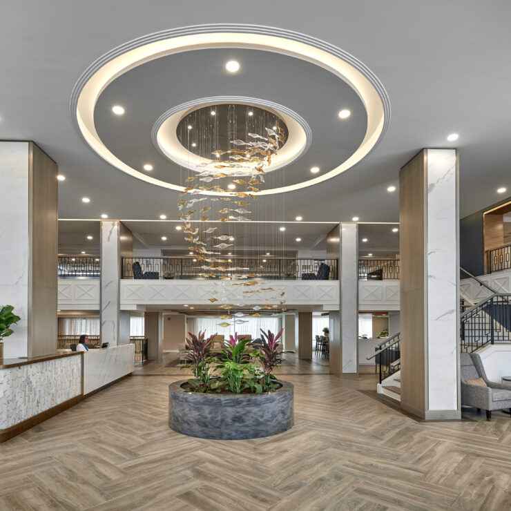 An inviting lobby features elegant decor, vibrant plants, and warm lighting, fostering a sense of community.