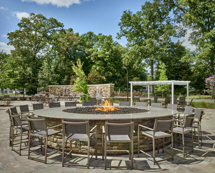 A welcoming outdoor space with a fire pit, surrounded by greenery and comfortable seating, perfect for gatherings.