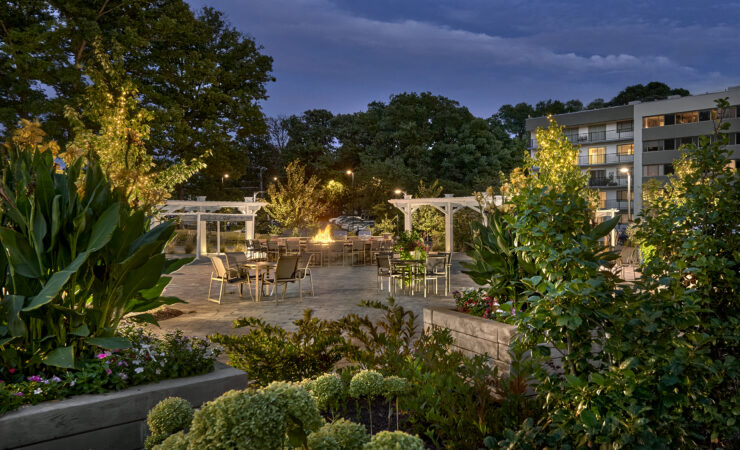 A beautifully lit outdoor gathering space, inviting community moments around a warm fire.