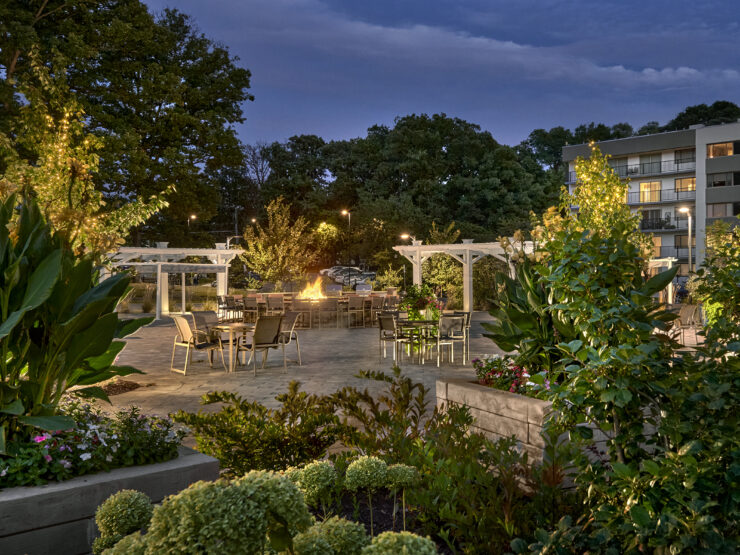 A beautifully lit outdoor gathering space, inviting community moments around a warm fire.