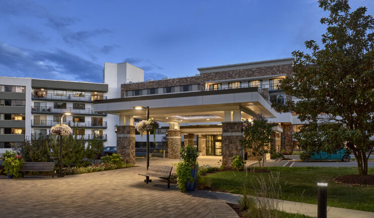 A welcoming entrance surrounded by vibrant gardens, inviting residents to enjoy community life together.