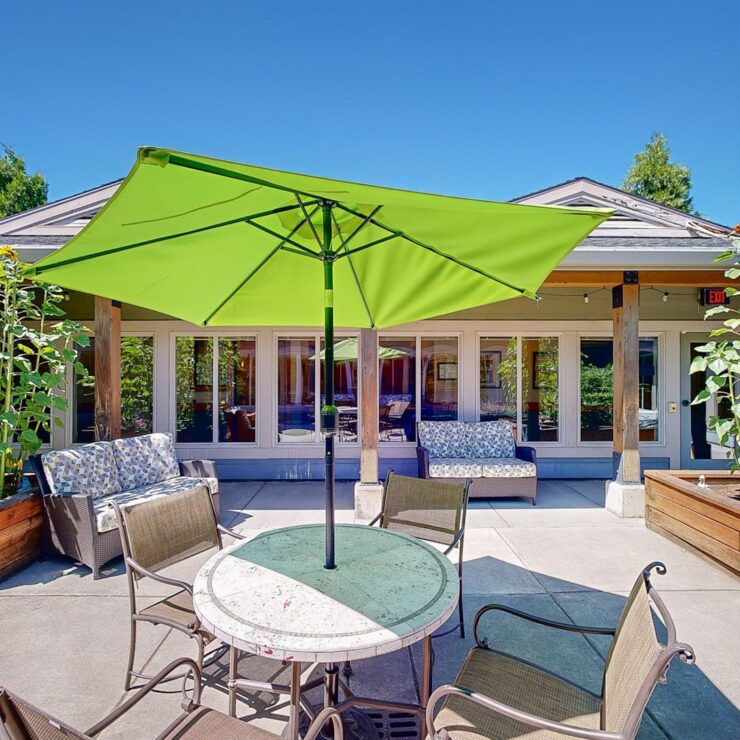 A vibrant outdoor space featuring comfortable seating, lush greenery, and a welcoming atmosphere for community gatherings.