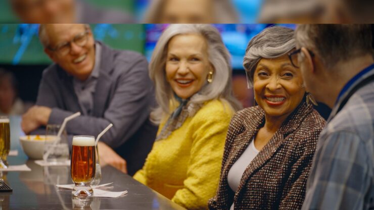 Lively conversation among friends, sharing laughter and drinks in a welcoming, vibrant atmosphere.