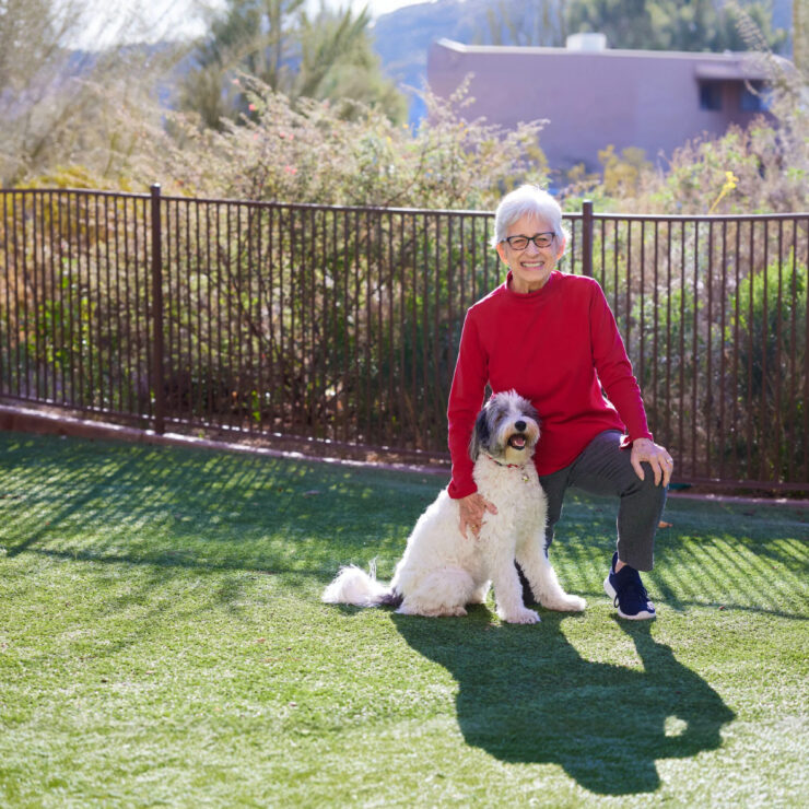 A joyful resident enjoys the sun with a friendly dog, highlighting a vibrant and welcoming community.