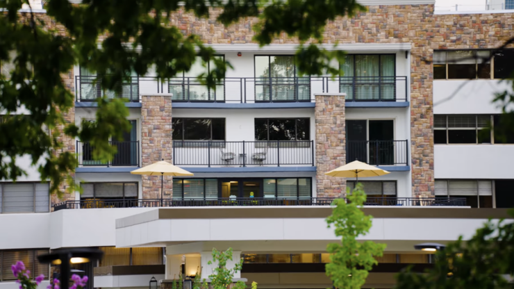 A welcoming residence with charming balconies, surrounded by lush greenery, fostering community and comfort.