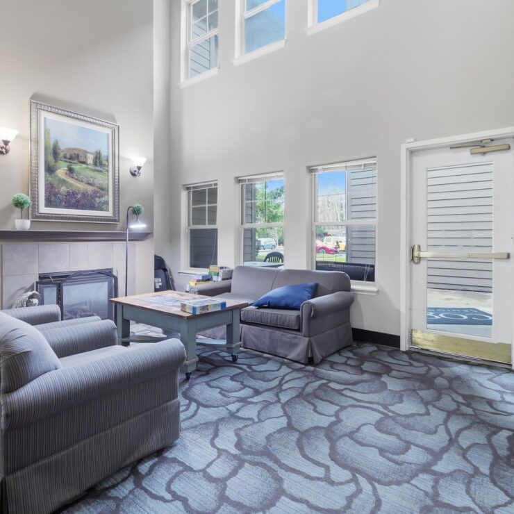 Bright common area with comfortable seating and a fireplace, perfect for relaxing and socializing.