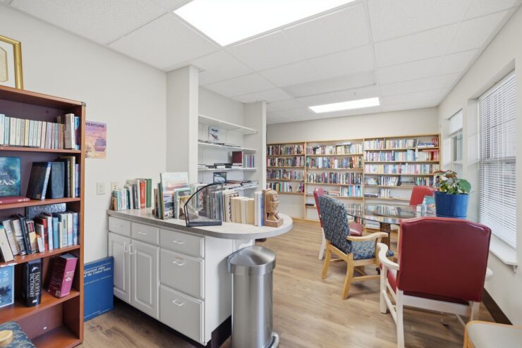 A welcoming library space filled with books, inviting chairs, and natural light, perfect for community gatherings.