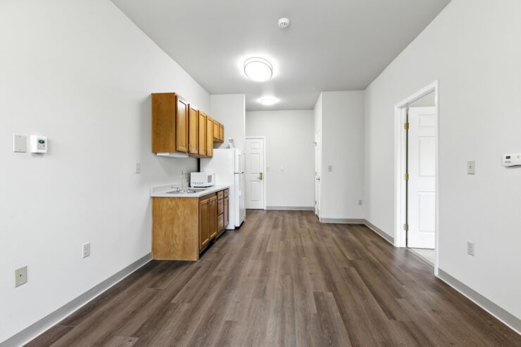Bright and clean kitchen space with warm wood floors and ample room for shared meals and activities.
