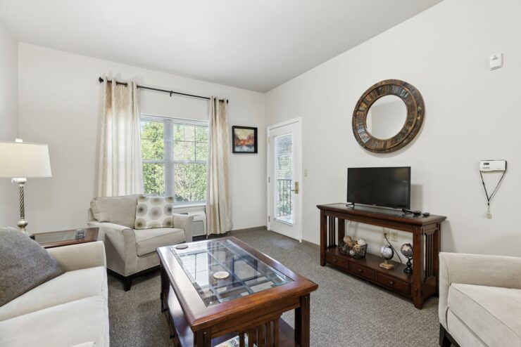 Bright living room with comfortable seating, natural light, and warm wooden accents.