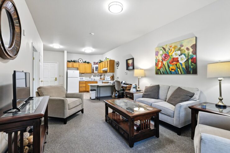 Bright living area with comfortable seating, warm lighting, and an inviting communal kitchen space.