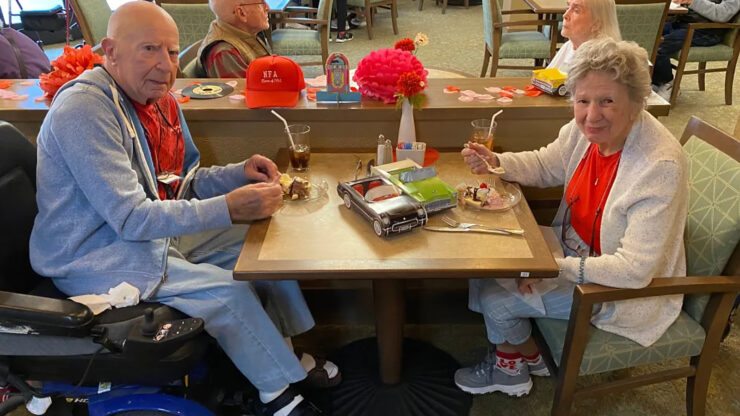 Seniors enjoying dessert together in a warm, welcoming dining area with festive decor.