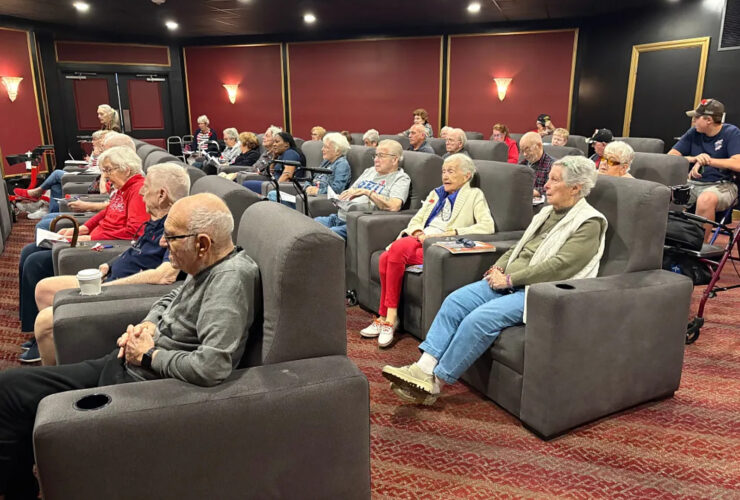 Residents enjoy a movie in a welcoming theater, fostering friendship and shared experiences.