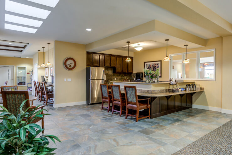 Bright common area with comfortable seating and a welcoming kitchen space for residents to gather.