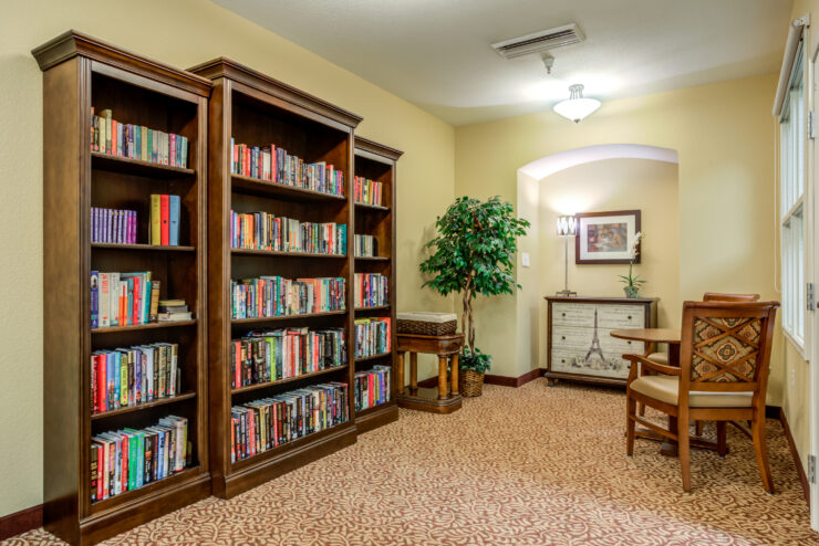 Bright, inviting reading nook with bookshelves, comfortable chairs, and warm decor in a retirement community.