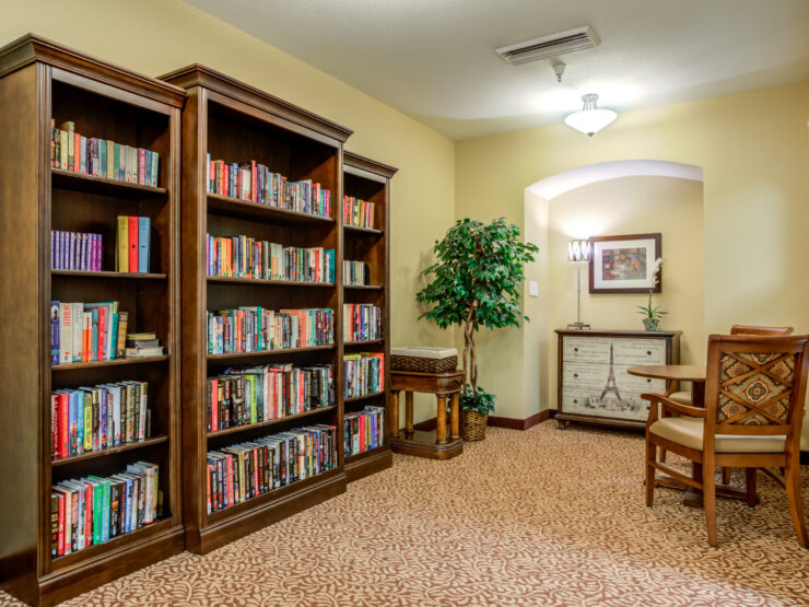 Bright, inviting reading nook with bookshelves, comfortable chairs, and warm decor in a retirement community.