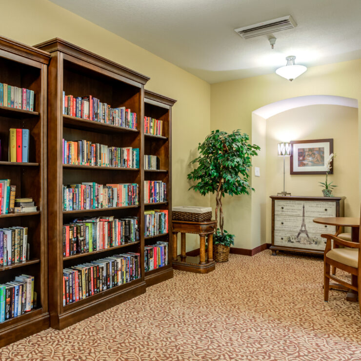 Bright, inviting reading nook with bookshelves, comfortable chairs, and warm decor in a retirement community.