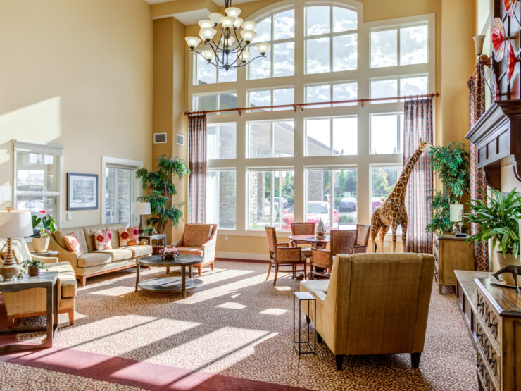 Sunlit living area with comfortable seating, plants, and large windows fostering community spirit.