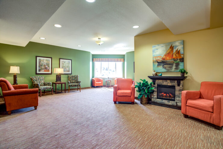 Spacious sitting area with comfortable chairs, warm lighting, and a welcoming fireplace.
