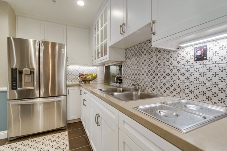 A bright, inviting kitchen with modern appliances and elegant tile work, perfect for community gatherings.