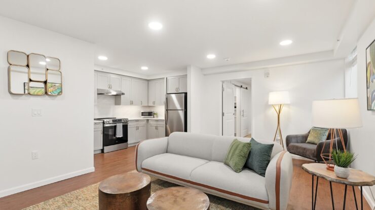 Bright and inviting living space with modern kitchen, comfortable seating, and warm lighting.