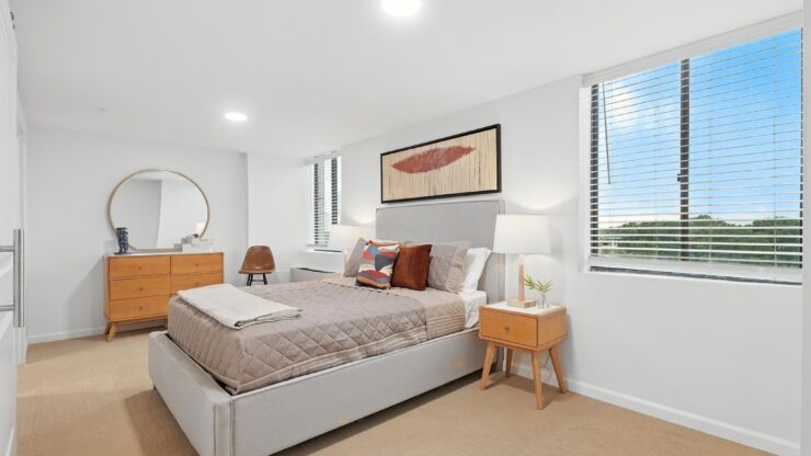 Bright, inviting bedroom with modern furnishings and large windows offering peaceful outdoor views.