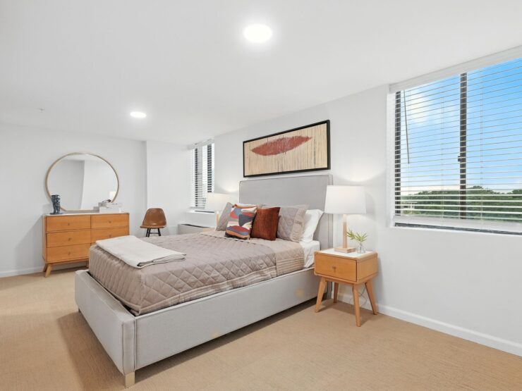 Bright, inviting bedroom with modern furnishings and large windows offering peaceful outdoor views.