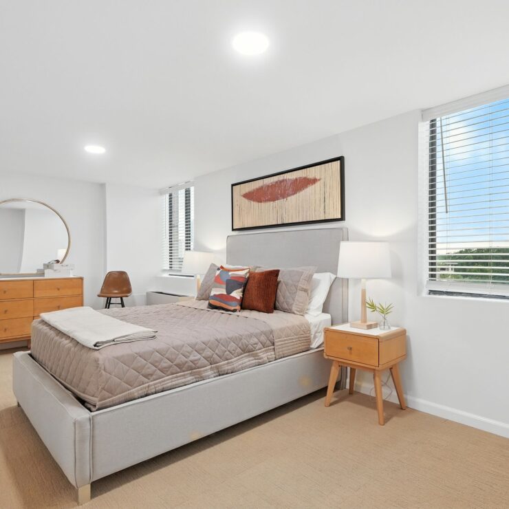 Bright, inviting bedroom with modern furnishings and large windows offering peaceful outdoor views.