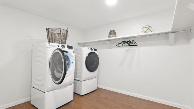 Bright, clean laundry room with modern machines and organized shelving for resident convenience.