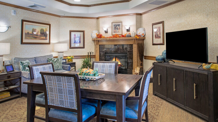 Warm living space with fireplace, comfortable seating, and a dining table for gatherings.